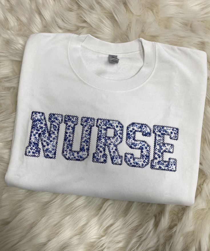 Nurse Embroidered Blue Floral Applique Sweatshirt Simple Doctor Pullover, Gift for Medical Field, Personalized RN Shirt - Etsy Blue Long Sleeve T-shirt With Embroidered Text, Blue Embroidered T-shirt For Fall, Blue Tops With Letter Embroidery For Winter, Blue Winter Tops With Letter Embroidery, Blue Tops With Letter Embroidery For Spring, Winter Blue Tops With Letter Embroidery, Blue Cotton Sweatshirt With Embroidered Graphics, Blue Crew Neck Top With Letter Embroidery, Blue Long Sleeve T-shirt With Embroidered Logo