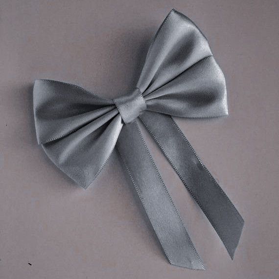 a close up of a silver bow on a white surface