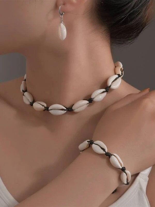 Cowrie Shell Choker, Shell Necklace, White Shell Necklace, Shell Bracelet, Shell Jewelry for Women,Shell Earings,Beach Jewelry, gift for her ------------------------------- Shell ● Necklace  + Bracelet+ earrings ------------------------------- Choker style Cowrie shell Necklace + Bracelet set Necklace :  ---------------- All the quoted dimensions are average and may vary slightly. DIMENSIONS: (L) 38CM (approximate) can be adjustable Handmade item Materials: Fine Cowrie shell, Handcrafted Closure White Shell Necklace, Hand Jewelry Rings, Necklace Shell, Cowrie Shell Necklace, Beachy Jewelry, Shell Choker, Women's Jewelry Sets, Maasai, Shell Bracelet