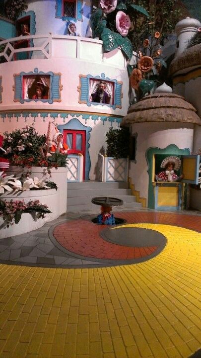 the inside of a doll house with flowers on display