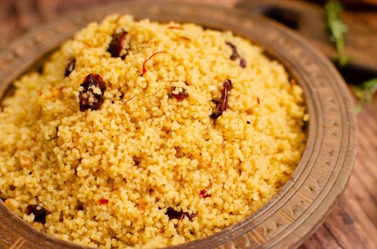 a wooden bowl filled with rice on top of a table