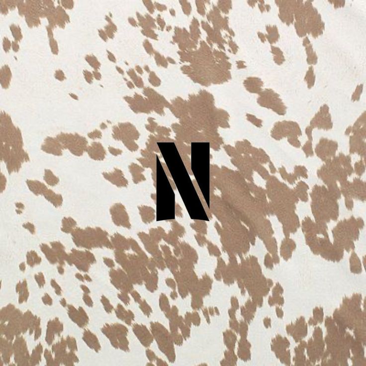 the letter n is made up of brown and white spots on a black background with an animal print