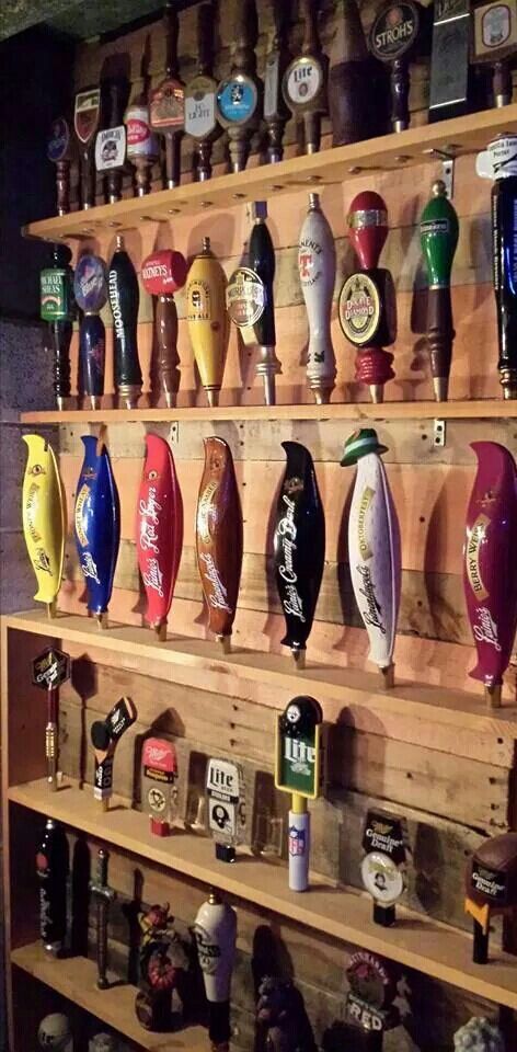 a wooden shelf filled with lots of different types of beer bottles on top of it