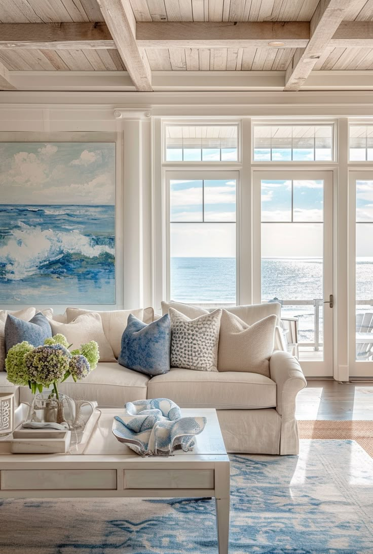 a living room filled with furniture next to a window covered in blue and white paintings