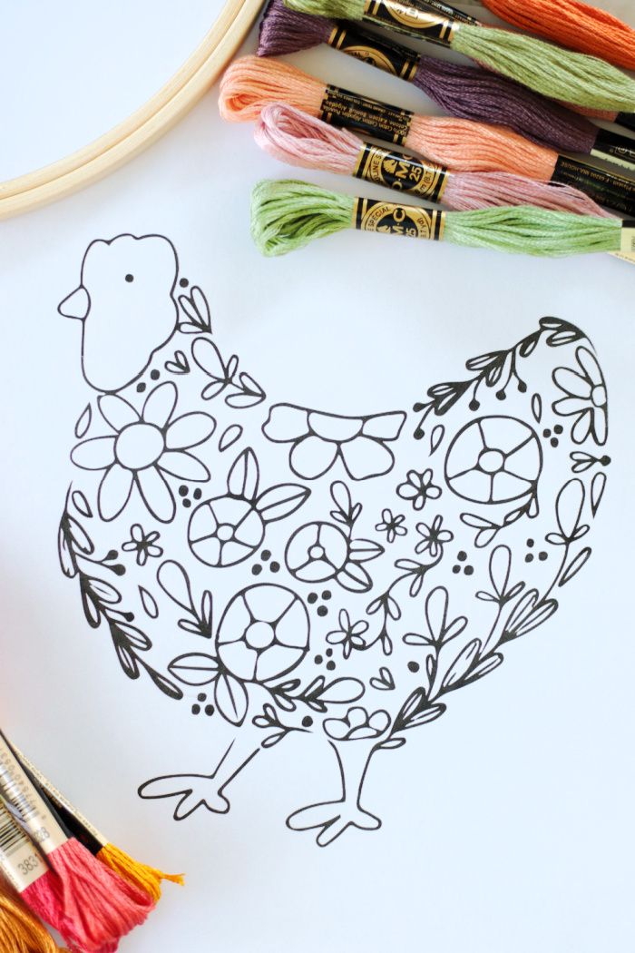 a drawing of a chicken surrounded by yarn and crochet hooks on a white surface