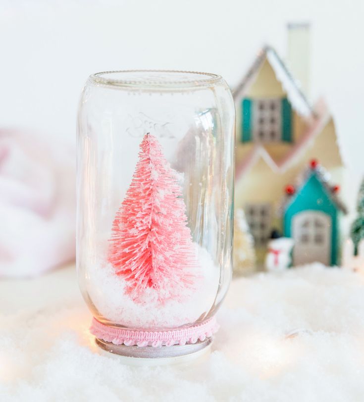 there is a glass jar with a small christmas tree inside