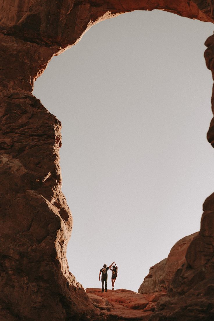 two people standing in the middle of a rocky area