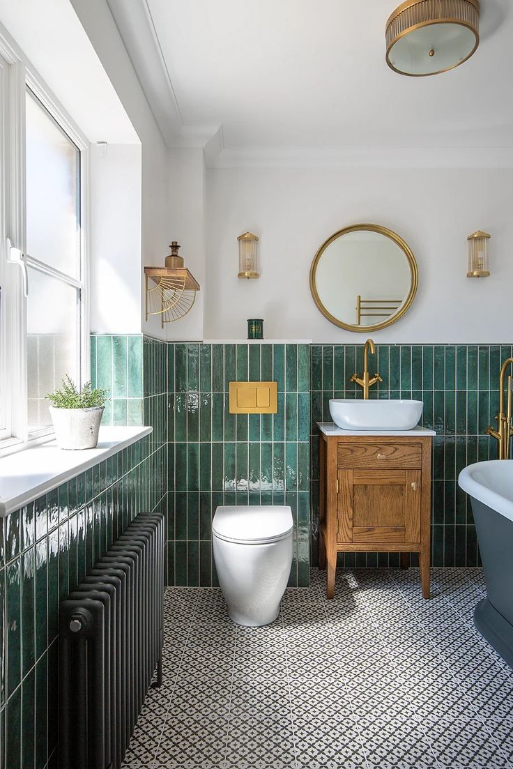 a bathroom with green tiles and white fixtures, including a wooden sink vanity next to a blue bathtub