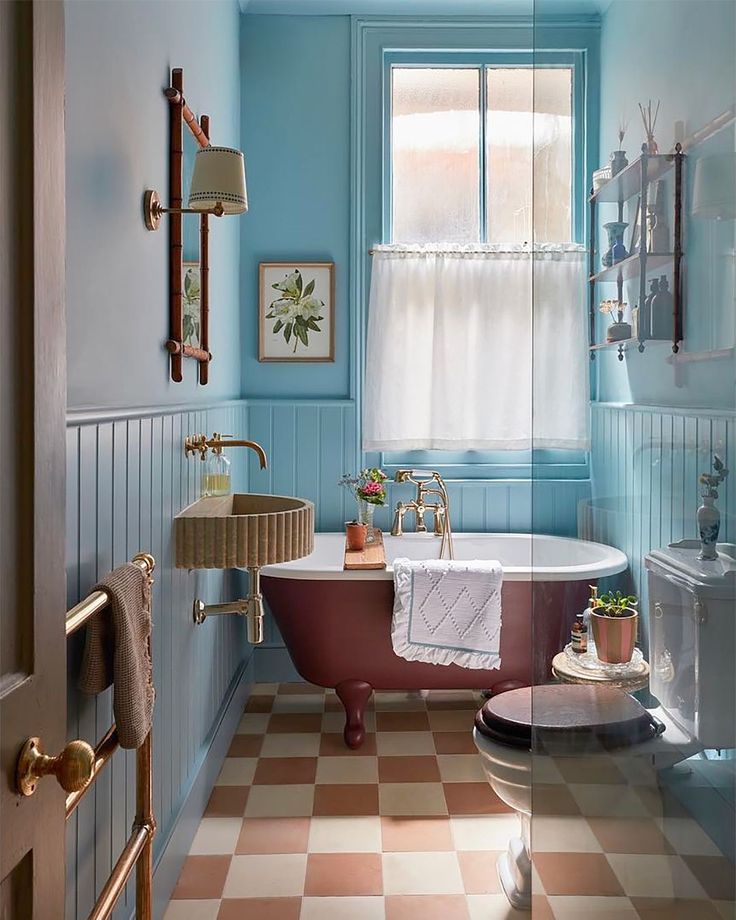 an old fashioned bath tub in a bathroom with checkered flooring and blue walls