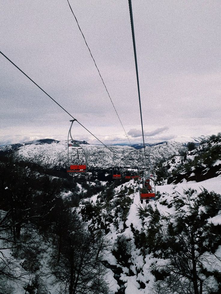 the ski lift is going over the snowy mountains