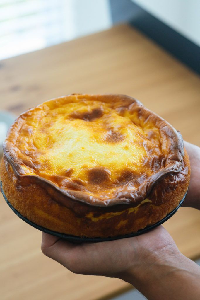 a person holding a baked pastry in their hand