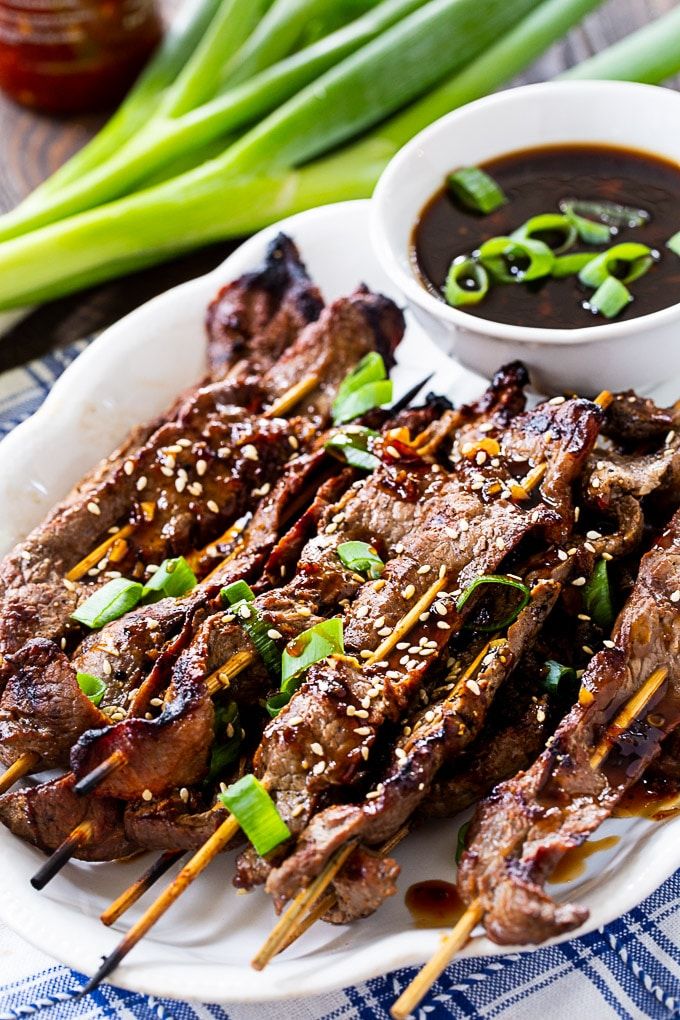 a plate topped with meat and veggies on skewers