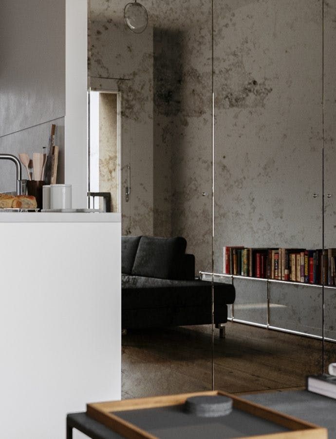 a living room filled with furniture and a book shelf next to a kitchen counter top