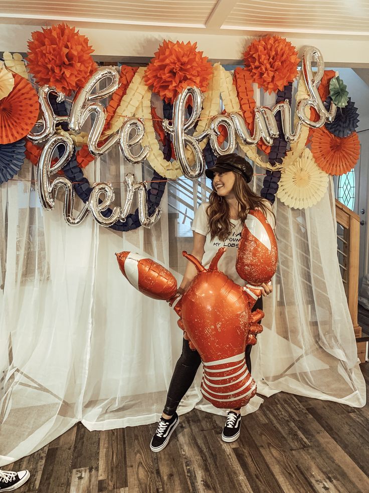 a woman sitting on top of a lobster balloon