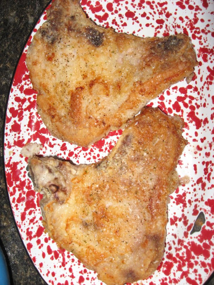 two pieces of chicken on a red and white plate