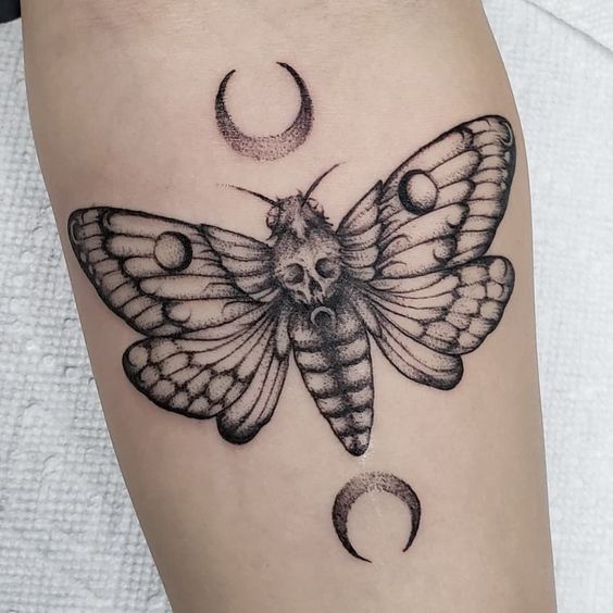 a black and white butterfly with crescent moon tattoo