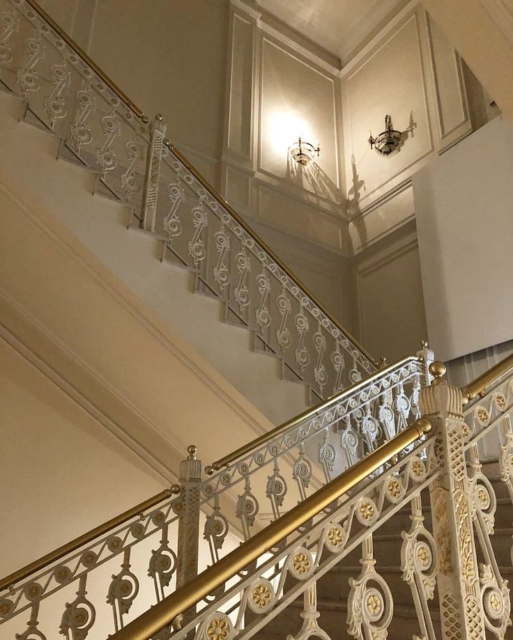 an ornate stair case in a building with chandelier