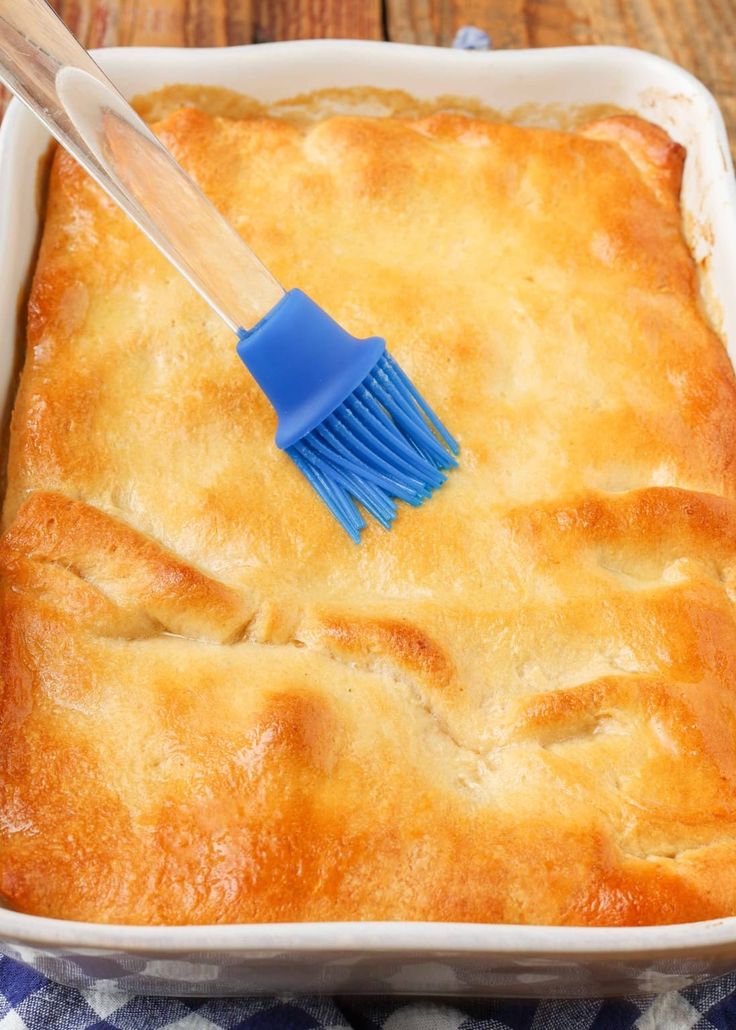 a square casserole dish with a blue brush in it