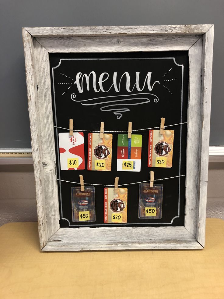 a chalkboard with some food on it and clothes pins hanging from the line in front of it