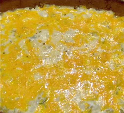 a casserole dish with cheese and other toppings in a brown bowl on a table