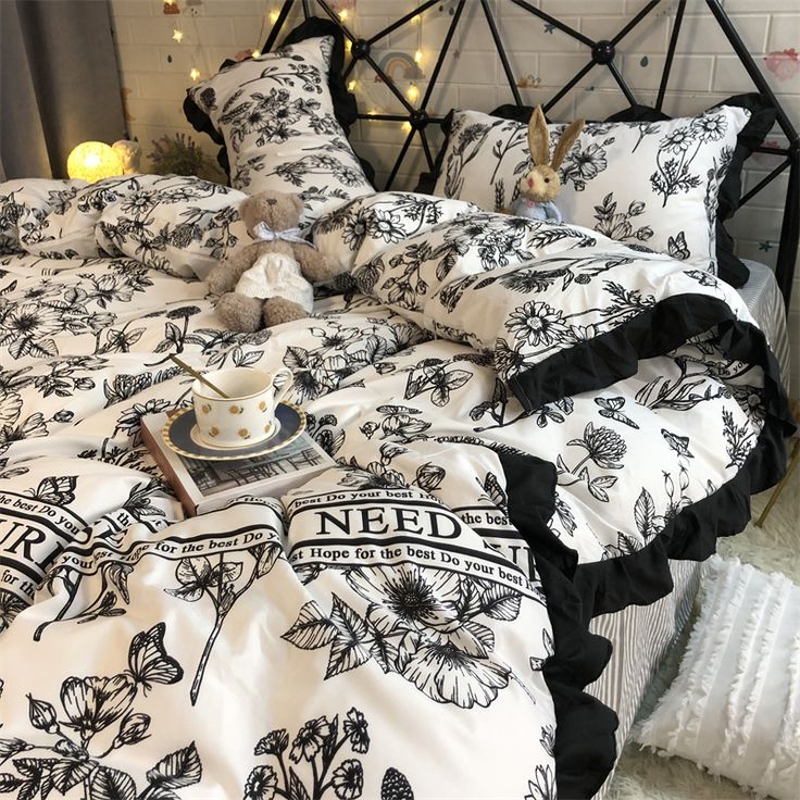 a bed covered in black and white flowers