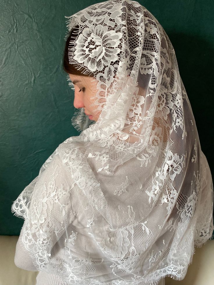 a woman wearing a veil with lace on it