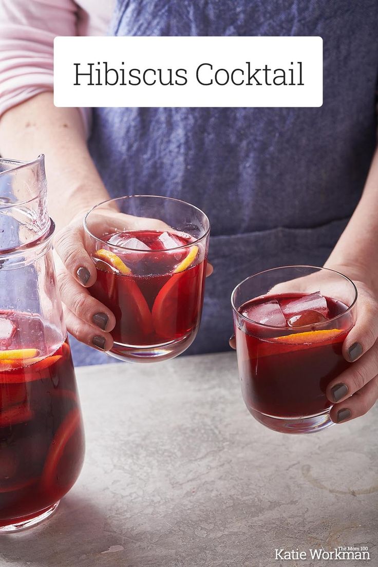 two people holding glasses filled with red liquid