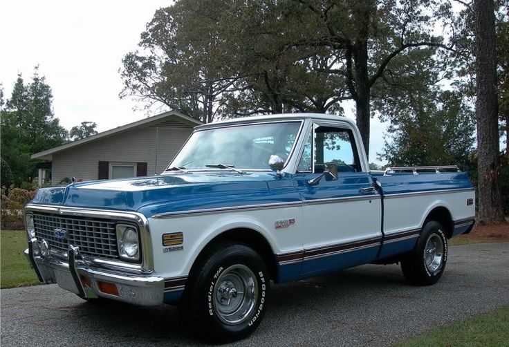 a blue and white truck parked in front of a house