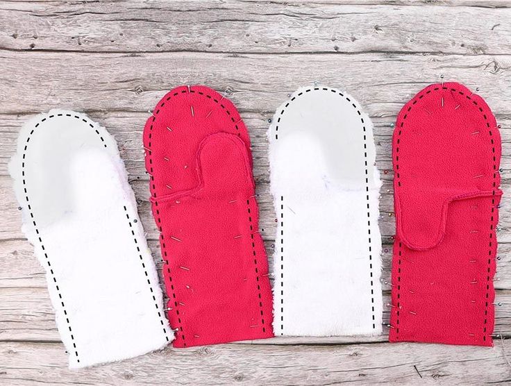 three red and white oven mitts sitting on top of a wooden table