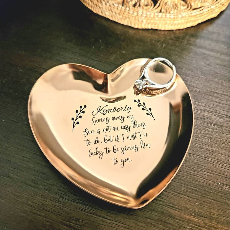 a heart shaped tray with a wedding ring on it and a basket in the background