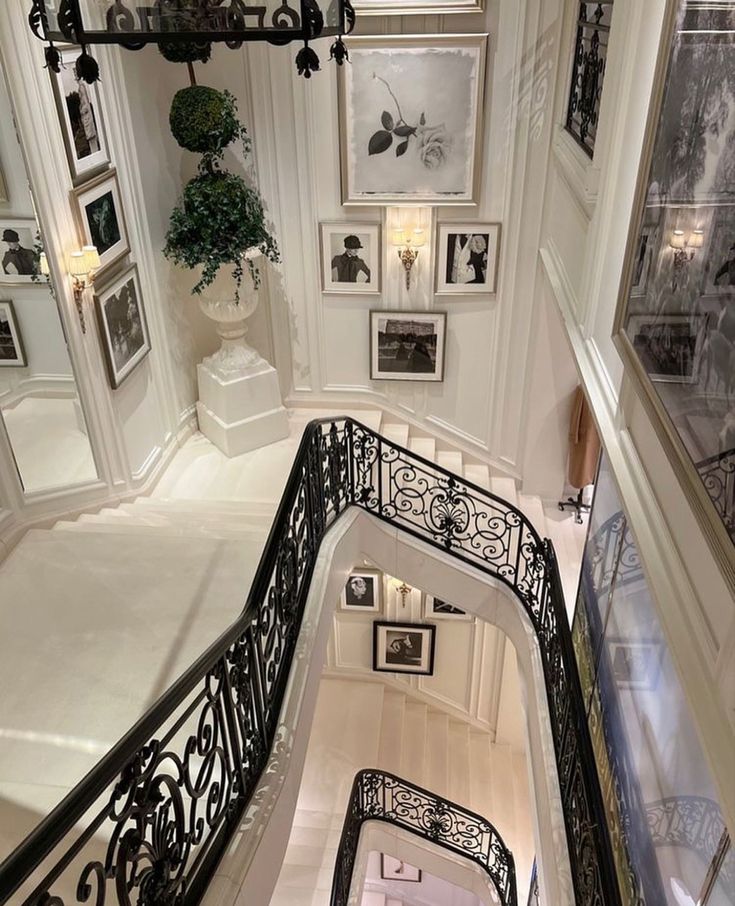 an ornate staircase with pictures on the wall