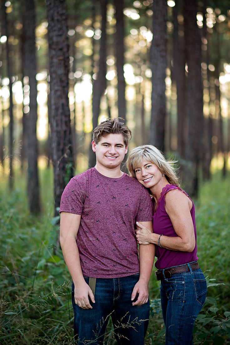 a man and woman are standing in the woods with their hands on each other's chest