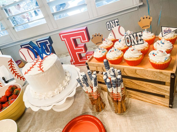 cupcakes, strawberries and other dessert items are on display at a baseball themed birthday party