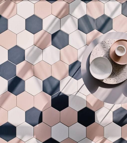 an overhead view of a table with two cups and saucers on it, in front of hexagonal tiles