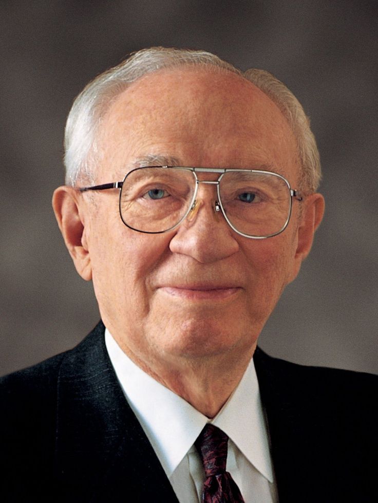 an older man wearing glasses and a suit