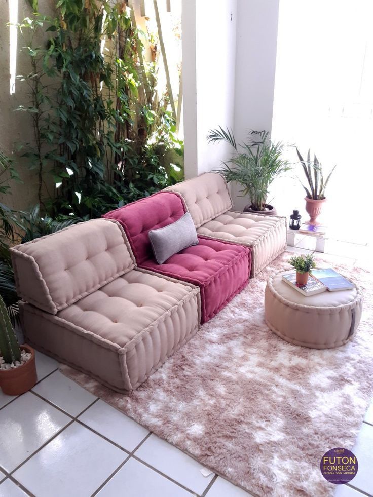 a living room filled with lots of furniture next to potted plants on top of a rug