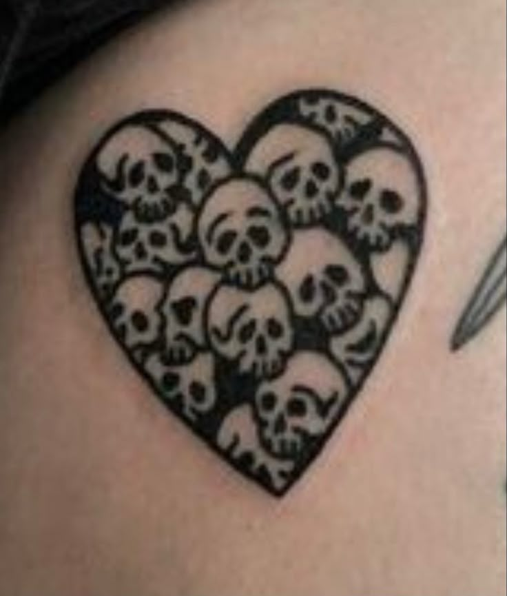 a black and white tattoo with skulls in the shape of a heart