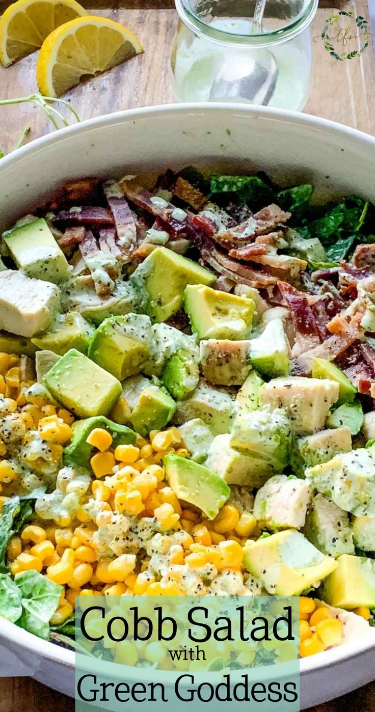 cobb salad with corn and avocado in a white bowl on a wooden table