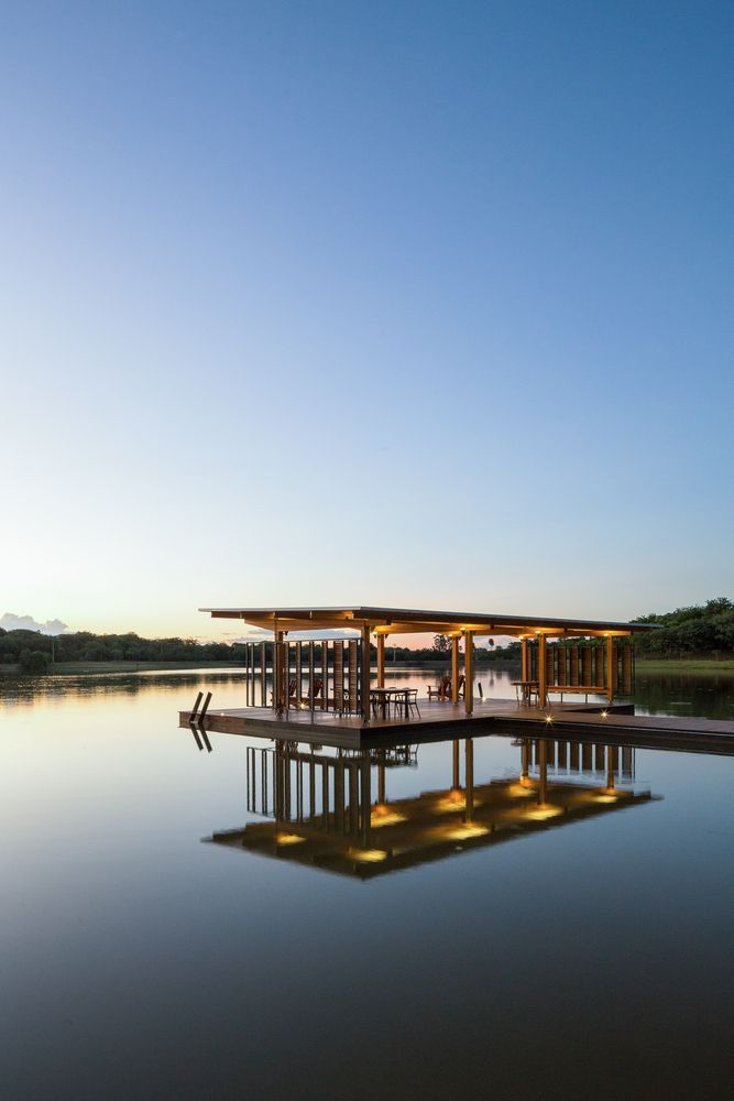 a large body of water sitting under a blue sky next to a building with lights on it