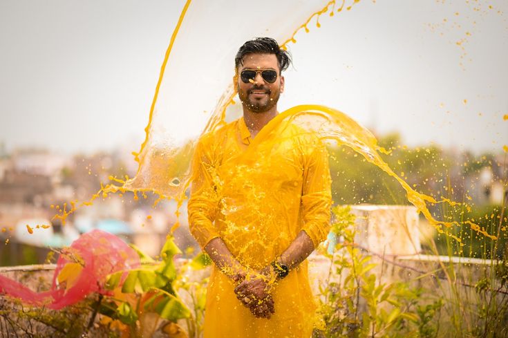 a man in a yellow outfit is throwing confetti on his face