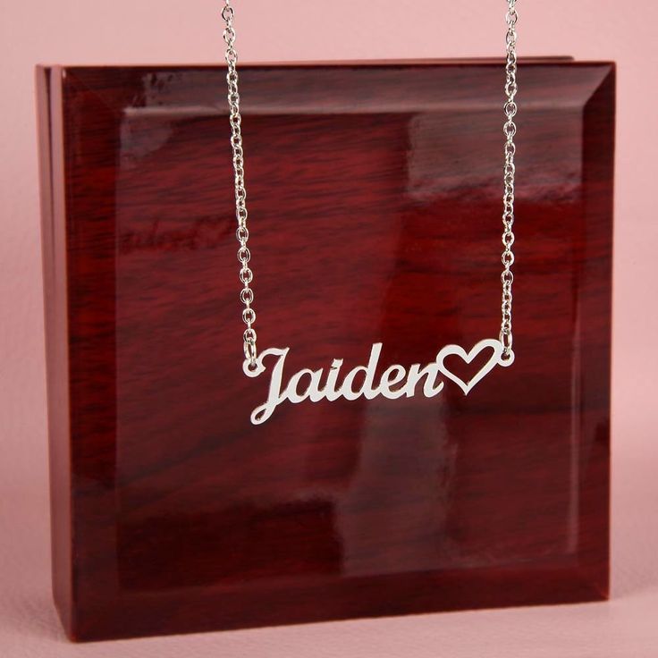 "Custom name necklace with a heart!  This item is CUSTOMIZABLE!  The custom necklace features a contemporary font with a heart at the end that is sure to become a favorite accessory!  MADE IN THE USA!   This stylish necklace features a cursive name design and heart symbol suspended on a 16\"-18\" adjustable cable chain, making it both personal and beautiful! Your necklace will be custom made upon ordering in the name or word of your choice, with up to 10 characters. NECKLACE SPECS:  Customized with up to 10 characters Polished stainless steel or 18K yellow gold finish Adjustable cable chain (16\"-18\") 9mm lobster clasp  MADE IN THE USA!   PRESENTATION: Your piece is lovingly packaged in a complimentary soft touch box for easy gifting. Elevate your presentation by upgrading to the mahogany Support Letter, Preschool Graduation, Heart Symbol, Losing A Loved One, Memorial Necklace, Stylish Necklace, Custom Name Necklace, Name Design, Led Spotlight