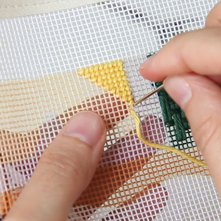 someone is stitching together some small pieces of fabric