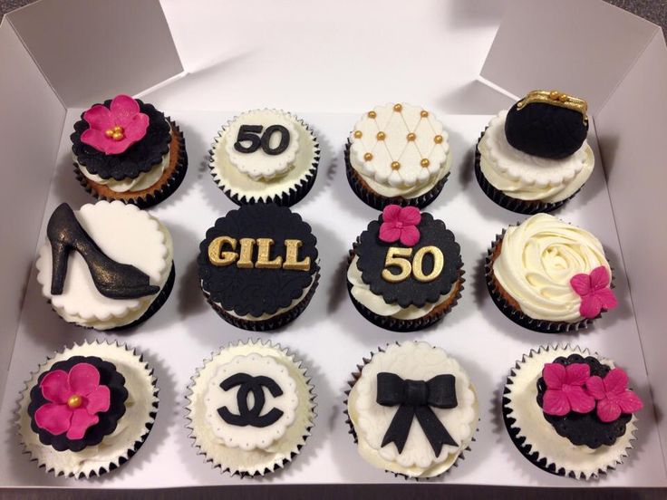 a box filled with lots of cupcakes covered in frosting and decorated like women's shoes