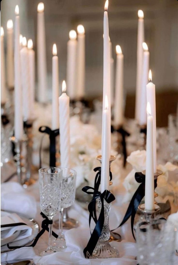 a table topped with lots of white candles