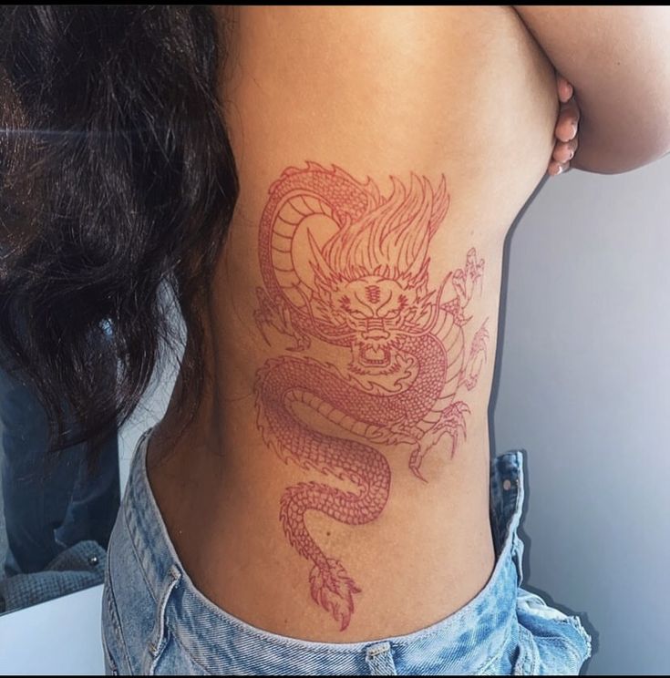 a woman with a dragon tattoo on her back