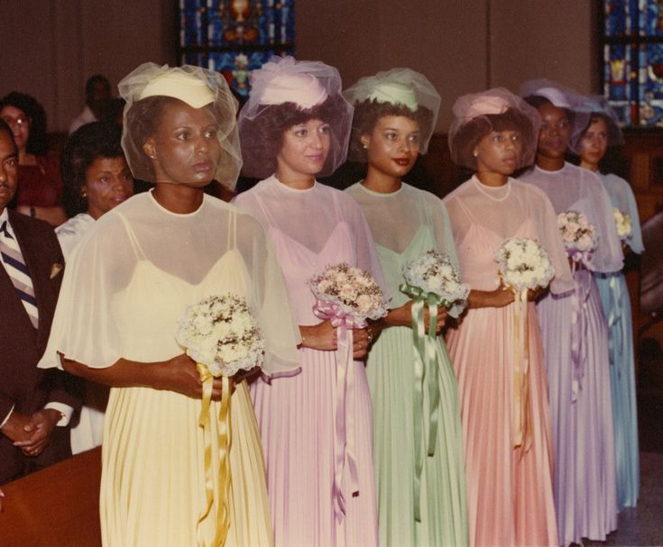 a group of women standing next to each other in front of a stained glass window