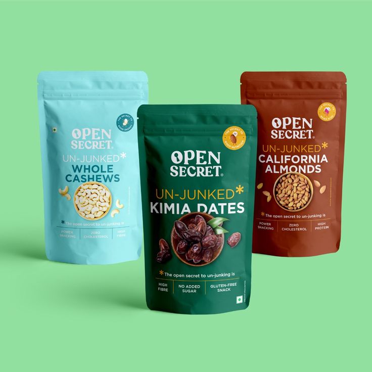 three bags of open secret snacks on a green background