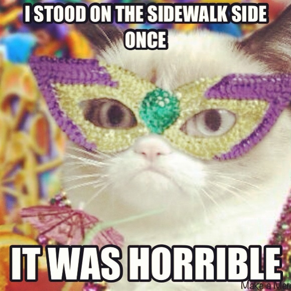 a white cat wearing a mardi gras mask with the caption boom dia