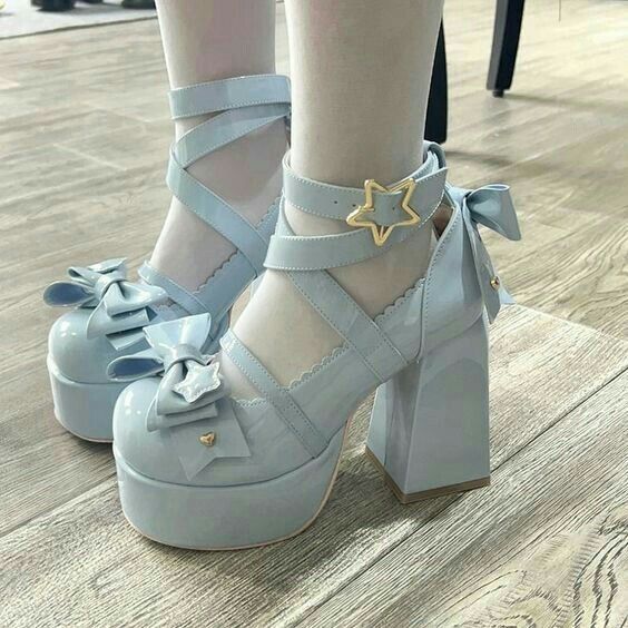 a close up of a person's feet wearing high heels with bows on them