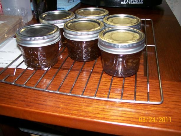 six jars of jam sitting on top of a rack